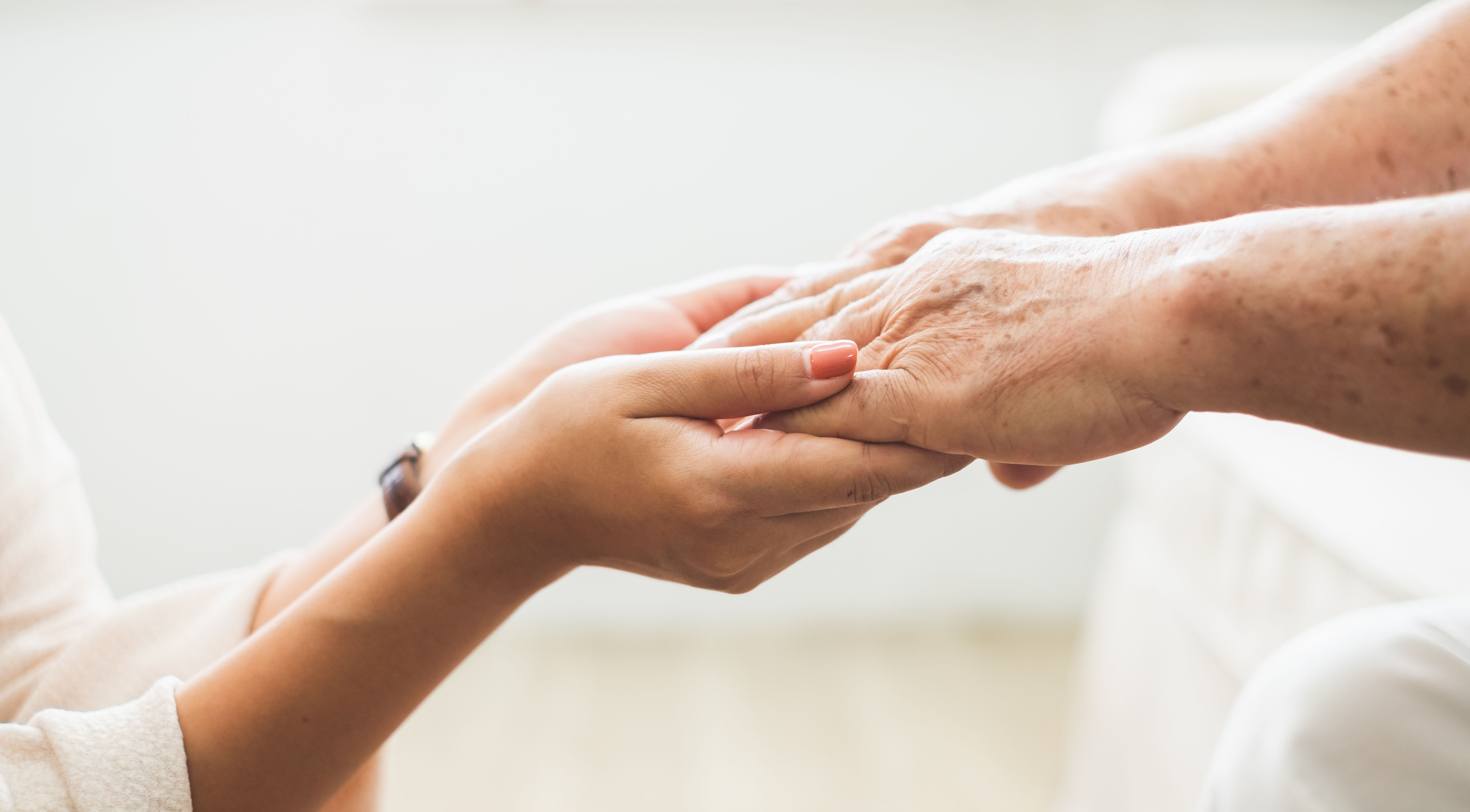 Close-up of the hands of a health volunteer next to those of an elderly woman. Concept of care. Aging concept. Volunteering concept.