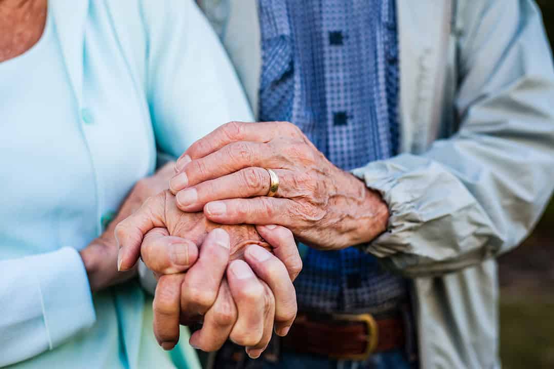 Close-up of the hands of a health volunteer next to those of an elderly woman. Concept of care. Aging concept. Volunteering concept.