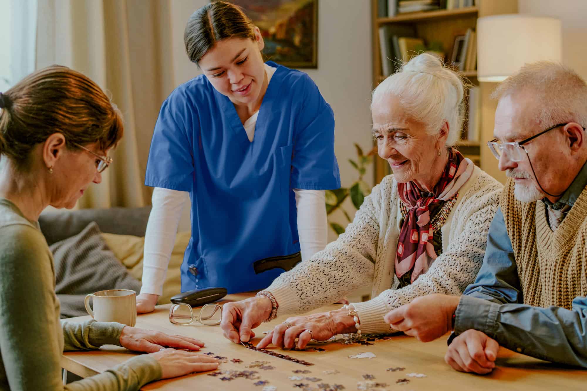 Seniors and caregiver enjoying jigsaw puzzle together