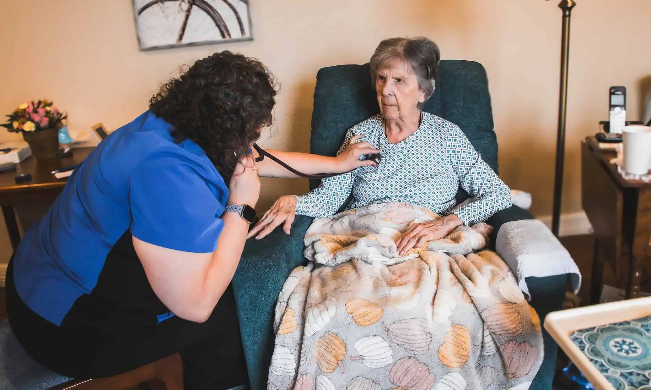 Nurse caring for elderly woman in a cozy home setting at Solaris Healthcare.