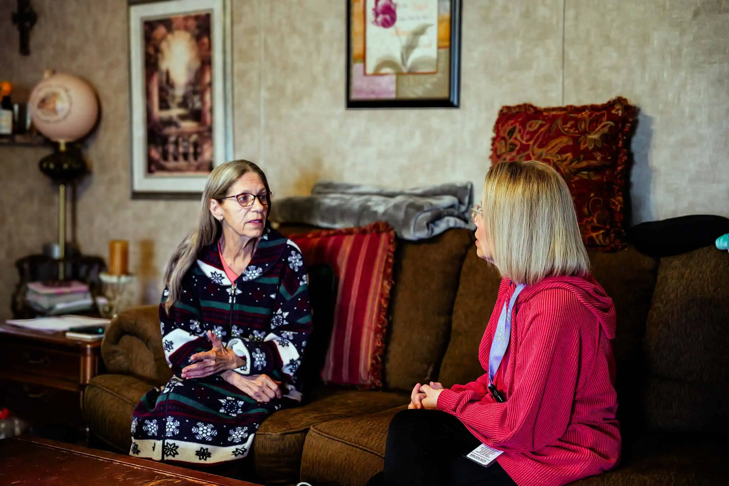 Healthcare professional checking elderly woman's health in a care facility.